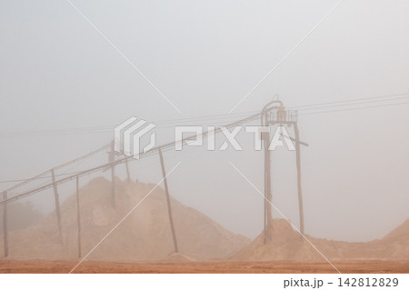 Details of a sand mining operation amidst winter fog, creating a fantastic landscape in Brazil; selective focus. 142812829