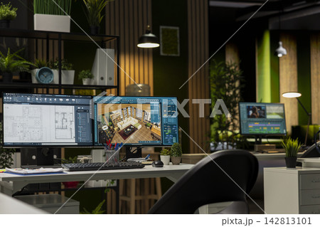 Empty design office with modern desk showcasing blueprint drafting and 3D modeling software on screen. Digital workspace emphasizes creative visualization in a professional environment. 142813101