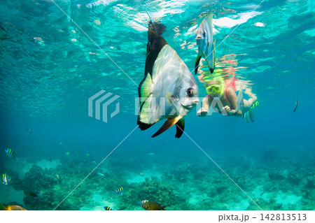 Happy family - active woman in snorkeling mask dive underwater, see tropical fishes in coral reef sea pool. Travel adventure, swimming activity and watersports on summer beach vacation with child. Happy family - active woman in snorkeling mask dive underwater, see tropical fishes in coral reef sea pool. Travel adventure, swimming activity and watersports on summer beach vacation with child. 142813513