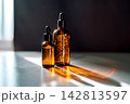Amber glass skincare serum bottles with sunlight reflection 142813597