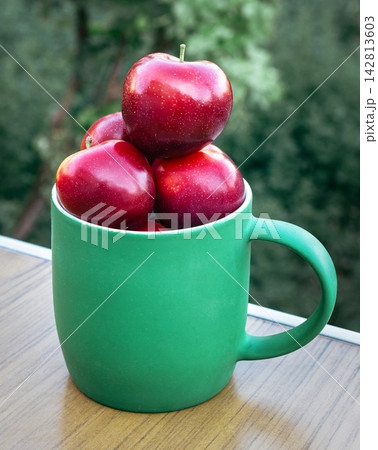 Fresh red plums in green mug, healthy diet food concept 142813603