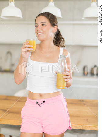 Young woman drinking smoothie in kitchen Young woman drinking smoothie in kitchen 142814250