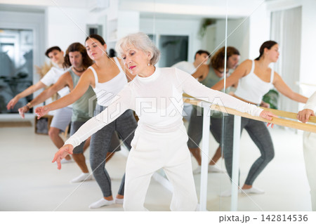 Elderly woman doing ballet at barre Elderly woman doing ballet at barre 142814536