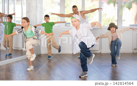 Tween boy dancer rehearsing krump dance in kids studio Tween boy dancer rehearsing krump dance in kids studio 142814564