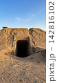 Concrete tunnel entrance leads into a dark sandy mound 142816102