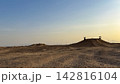 Desert landscape with earthen mounds under a clear sky 142816104