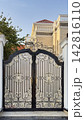 Ornate black and gold wrought iron gate outside a luxury villa 142816110