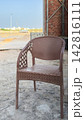 Brown plastic chair standing outdoors near a brick wall 142816111