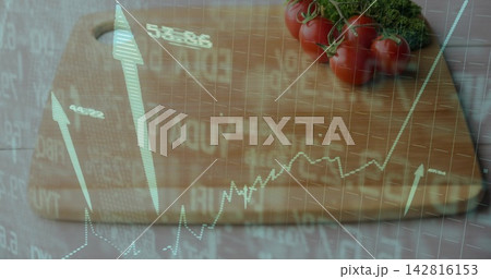 Displaying wood board handle holding tomatoes on vine and herb at kitchen counter with stock charts 142816153