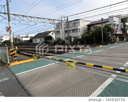 遮断機が下りた住宅街の踏切と複数の線路 142816718