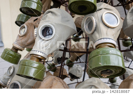 Vintage gas masks arranged on a metal rack, featuring different designs and colors, highlighting their historical significance and unique features Vintage gas masks arranged on a metal rack, featuring different designs and colors, highlighting their historical significance and unique features 142818087