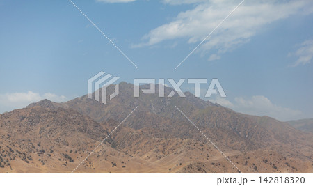Mountainous region features rocky terrain and sparse vegetation beneath a clear blue sky, highlighting the natural landscape and geological formations Mountainous region features rocky terrain and sparse vegetation beneath a clear blue sky, highlighting the natural landscape and geological formations 142818320