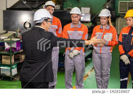 Angry factory manager confronting engineering team. Strict leadership and workplace conflict in industrial manufacturing environment. 142818807