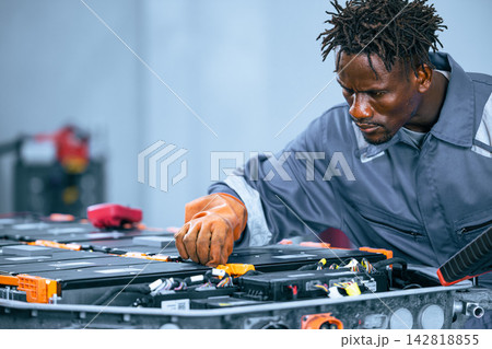 EV battery service mechanic working electric car lithium ion Battery pack maintenance garage 142818855