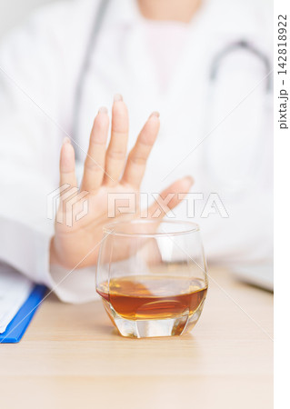 Doctor hand stop to refuse Whisky, quitting drink for healthy liver, prevent Alcoholic cirrhosis and cancer, World No Alcohol Day, medical advice for sobriety and Alcoholism and addiction concept Doctor hand stop to refuse Whisky, quitting drink for healthy liver, prevent Alcoholic cirrhosis and cancer, World No Alcohol Day, medical advice for sobriety and Alcoholism and addiction concept 142818922