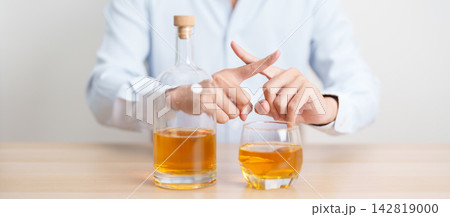 Man making stop hand gesture to refuse a glass of whiskey, Healthy man say no to alcohol drink, stop alcoholism and addiction concept. Responsible man reject a drink before driving and quit booze Man making stop hand gesture to refuse a glass of whiskey, Healthy man say no to alcohol drink, stop alcoholism and addiction concept. Responsible man reject a drink before driving and quit booze 142819000