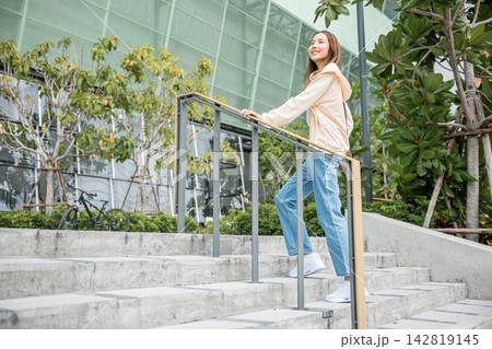Close-up of a woman's legs in sneakers conquering the city stairway. Each step signifies determination, progress, and her unwavering pursuit of success and achievement. step up Close-up of a woman's legs in sneakers conquering the city stairway. Each step signifies determination, progress, and her unwavering pursuit of success and achievement. step up 142819145