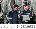 Engineers Monitor Machine Operation Using Laptop in Heavy Industry Factory. 142819631