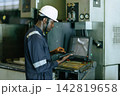African Black Worker Engineer Monitors Machinery Operations in a Heavy industry Factory During Working Hours. 142819658