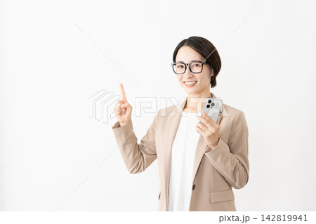 スマトフォンを使う眼鏡をかけたスーツ姿の女性 スマトフォンを使う眼鏡をかけたスーツ姿の女性 142819941
