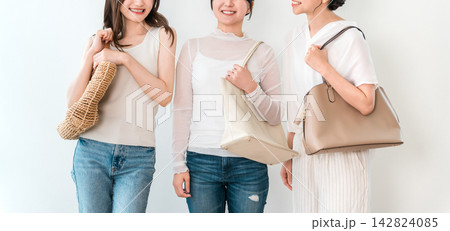 バッグを持って並ぶおしゃれな若い女性3人のファッションイメージ バッグを持って並ぶおしゃれな若い女性3人のファッションイメージ 142824085