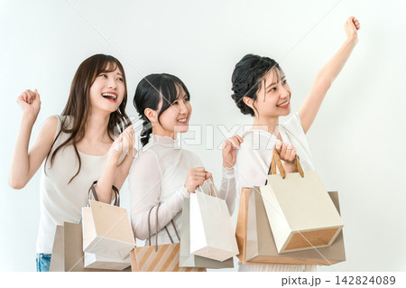 ショッピングバッグを持って買い物を楽しむ笑顔の若い女性3人 ショッピングバッグを持って買い物を楽しむ笑顔の若い女性3人 142824089