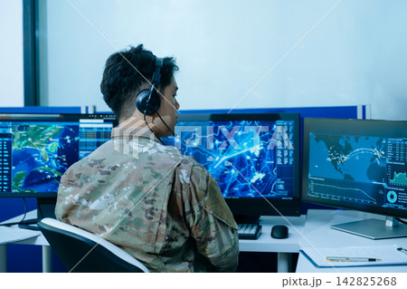Military operator in camouflage uniform analyzing tactical cyber security data and digital radar networks on multi-monitor displays Military operator in camouflage uniform analyzing tactical cyber security data and digital radar networks on multi-monitor displays 142825268