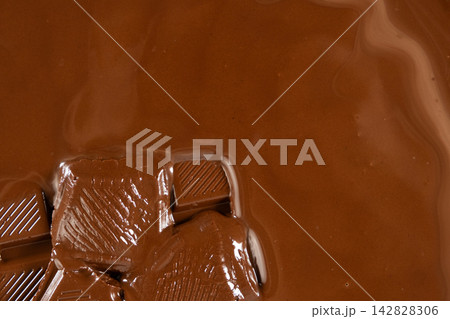 Melting chocolate pieces in melted chocolate close-up Melting chocolate pieces in melted chocolate close-up 142828306