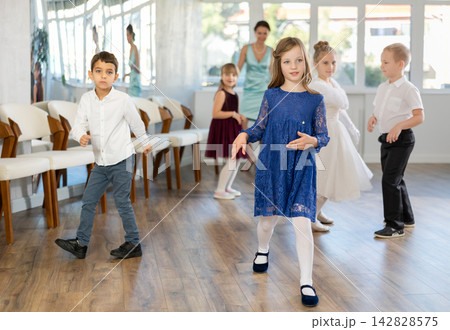 Preteen girl dancing twist with classmates during school party 142828575