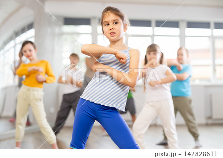 Dance lesson for children - girls and boys learn modern dances in pairs Dance lesson for children - girls and boys learn modern dances in pairs 142828611