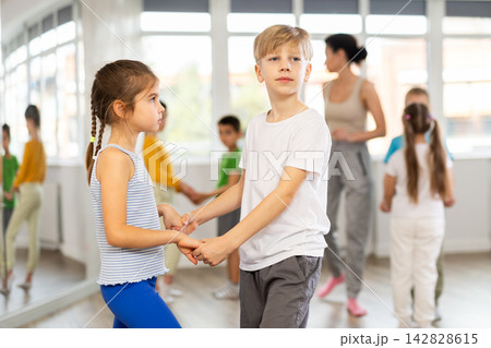 Girl paired up with boy and training to perform slow couple dance, rehearse performance. 142828615