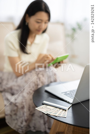 テーブルの上に乗った通帳と一万円札のクローズアップ 142829261