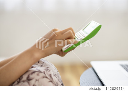 計算機を使う女性の手元のクローズアップ 142829314