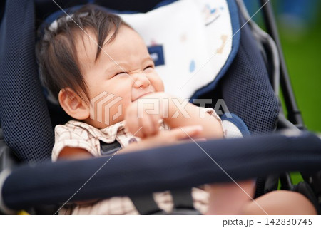 ベビーカーに乗って笑顔を見せる赤ちゃん 142830745