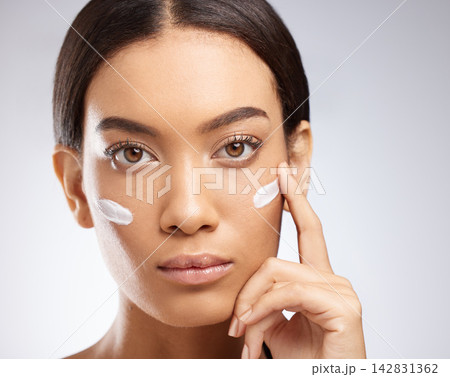 Sunscreen, cream and portrait of woman for skincare and dermatology in studio background. Calm, girl and apply lotion moisturizer on face for healthy glow or self care in beauty with cosmetics 142831362