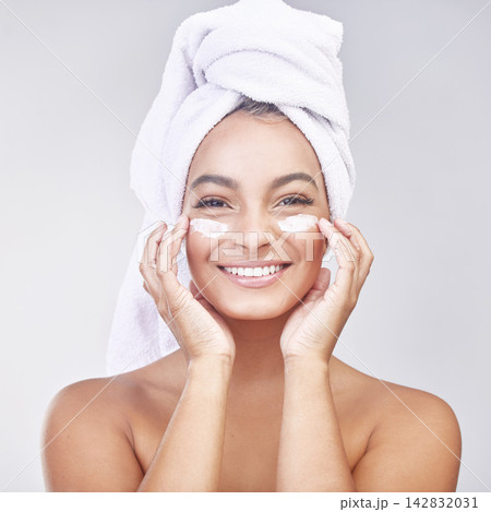 Happy woman, portrait and skincare with cream for facial treatment, hygiene or beauty on a gray studio background. Face of young female person or model with smile, anti aging ointment or healthy skin Happy woman, portrait and skincare with cream for facial treatment, hygiene or beauty on a gray studio background. Face of young female person or model with smile, anti aging ointment or healthy skin 142832031