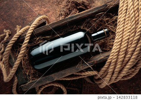 Dark glass bottle of hard liquor in a vintage wooden box. Dark glass bottle of hard liquor in a vintage wooden box. 142833118