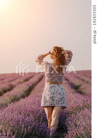 Lavender field woman travel, woman walking through blooming purple lavender flowers in a sunny outdoor meadow with soft summer lighting Lavender field woman travel, woman walking through blooming purple lavender flowers in a sunny outdoor meadow with soft summer lighting 142833305