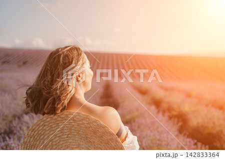 Woman lavender field sitting amidst blooming flowers during a golden sunset with copy space for text 142833364