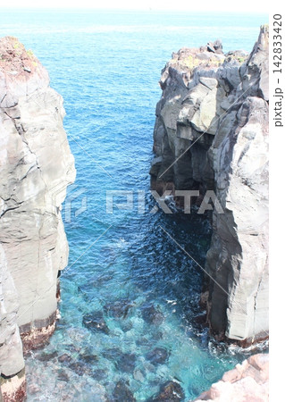 岩壁の間に広がる青い海と海食地形 岩壁の間に広がる青い海と海食地形 142833420