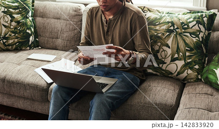 Paperwork, laptop and man sitting on sofa in home for finance, accounting and debt in living room. Computer, documents and online for insurance, bills and overdue payment with budget in apartment 142833920