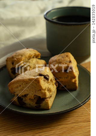 手作りのチョコチップスコーンとマグカップのコーヒー 手作りのチョコチップスコーンとマグカップのコーヒー 142835019