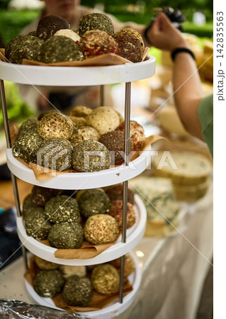 Gourmet Cheese Balls with Herbs and Spices on Tiered Stand at Market 142835563