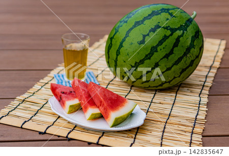 冷たいお茶とカットスイカのある夏の風景 142835647
