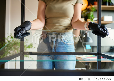 Woman installing glass shelf into metal shelving unit Woman installing glass shelf into metal shelving unit 142835995
