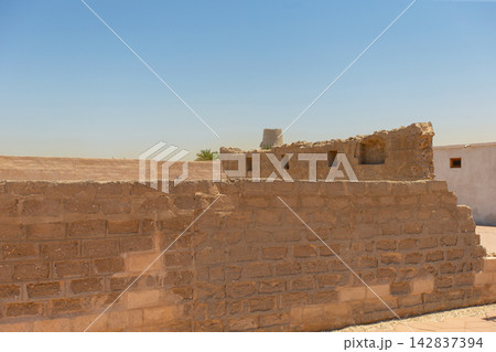 Historic site shows remains of old stone walls and structures under blue sky during daytime in desert area Historic site shows remains of old stone walls and structures under blue sky during daytime in desert area 142837394