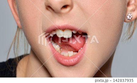 Playful child sticks out her tongue in neutral studio closeup with mischievous joy Playful child sticks out her tongue in neutral studio closeup with mischievous joy 142837935