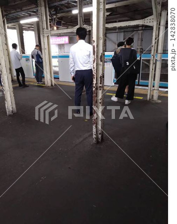 朝の駅ホームで電車を待つ通勤客の日常風景 朝の駅ホームで電車を待つ通勤客の日常風景 142838070