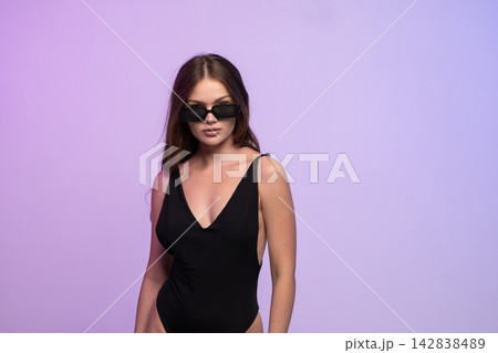 Woman posing in black swimsuit and sunglasses, embracing summer fashion and confident lifestyle with style Woman posing in black swimsuit and sunglasses, embracing summer fashion and confident lifestyle with style 142838489