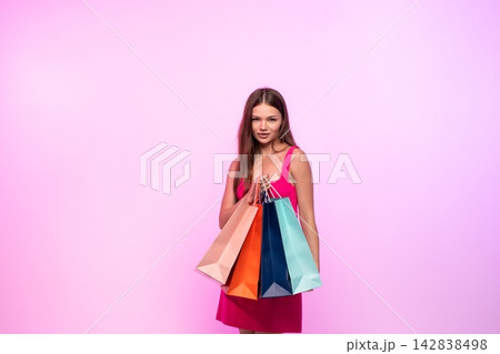 Woman holding colorful shopping bags, celebrating successful retail therapy and consumer lifestyle on pink background Woman holding colorful shopping bags, celebrating successful retail therapy and consumer lifestyle on pink background 142838498